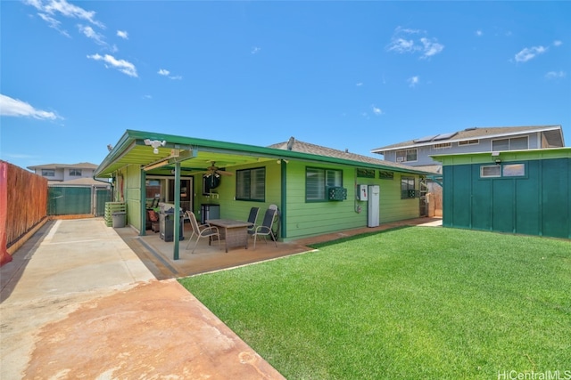 rear view of property with a patio area, a lawn, and ceiling fan