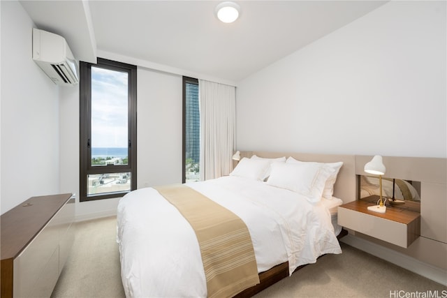 bedroom with a wall unit AC and light colored carpet