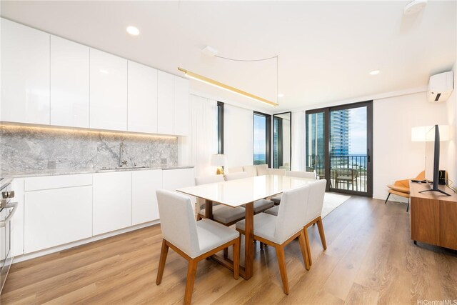 dining area with light wood finished floors, recessed lighting, a wall unit AC, and floor to ceiling windows
