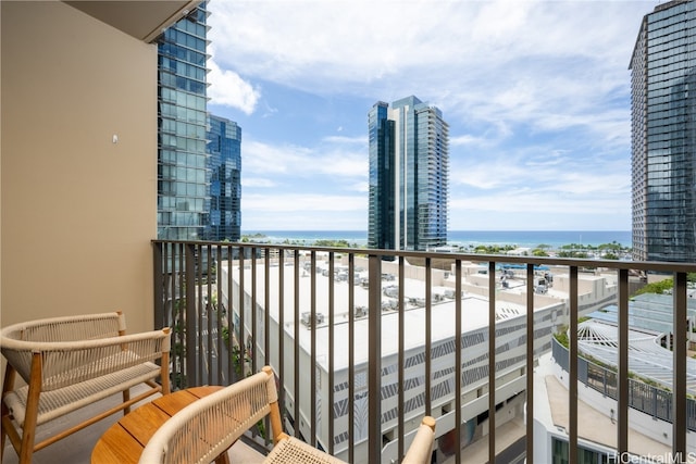 balcony featuring a water view and a beach view