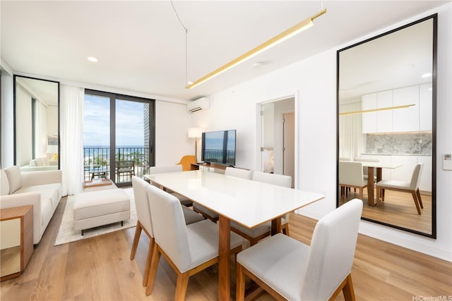 dining area with expansive windows, recessed lighting, a wall unit AC, and light wood finished floors