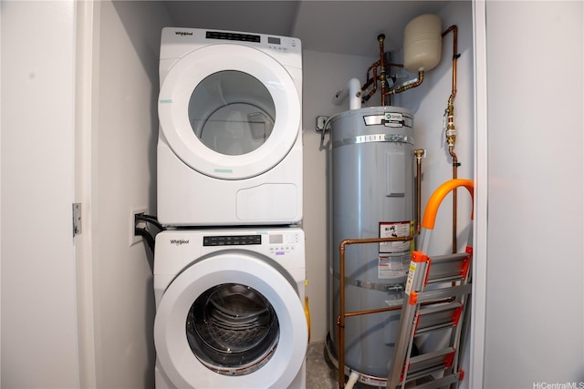washroom with water heater, stacked washer and clothes dryer, and laundry area