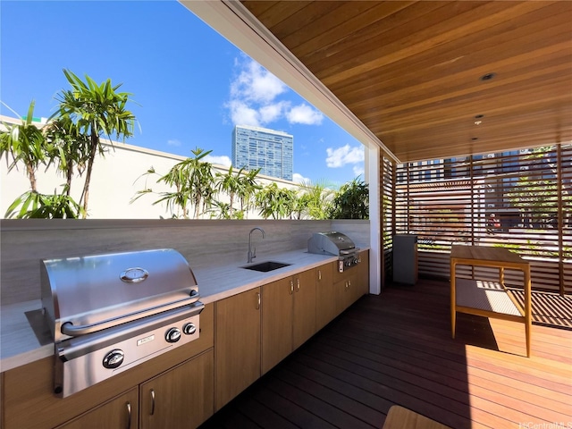 deck featuring a sink, a grill, and exterior kitchen