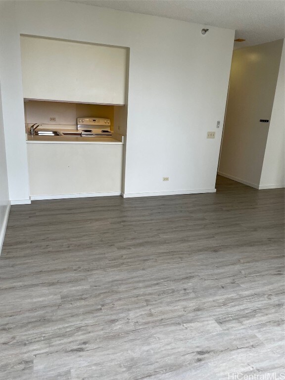 unfurnished living room featuring hardwood / wood-style floors and a textured ceiling