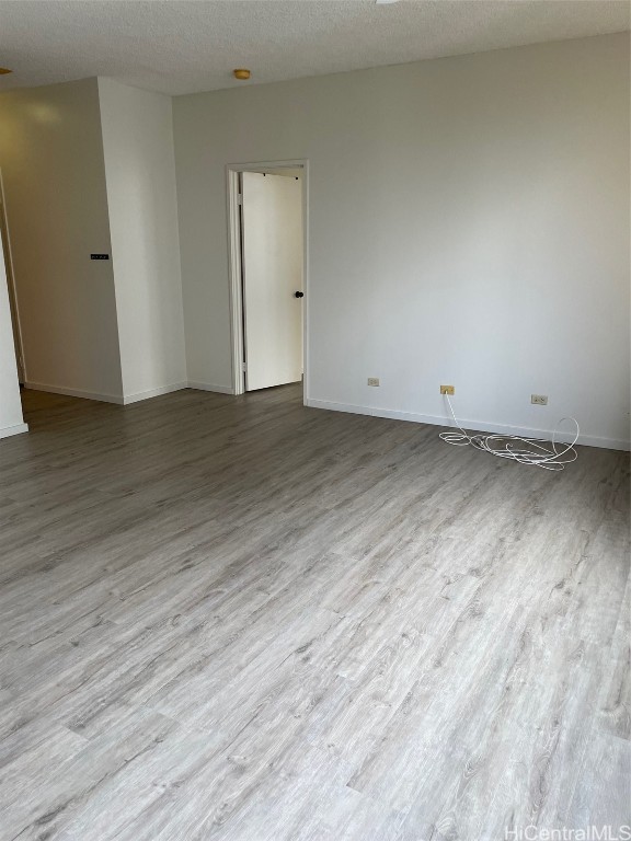 spare room featuring a textured ceiling and light wood-type flooring