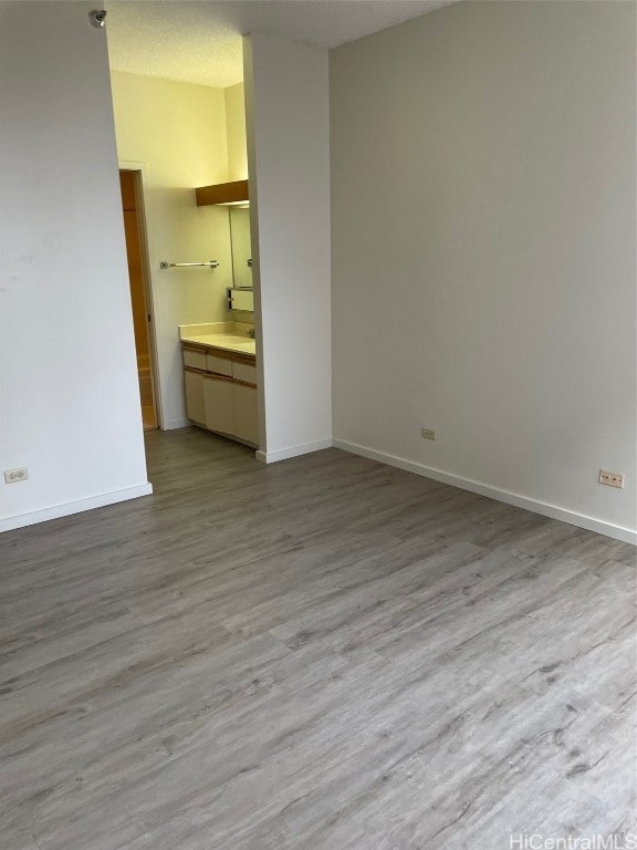 empty room with light hardwood / wood-style flooring and a textured ceiling