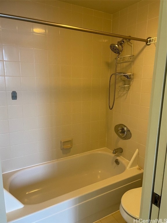 bathroom featuring tile patterned floors, tiled shower / bath combo, and toilet