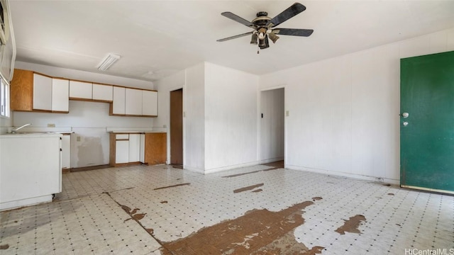 kitchen featuring ceiling fan and white cabinets