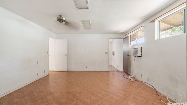 spare room with a wall unit AC and light parquet floors