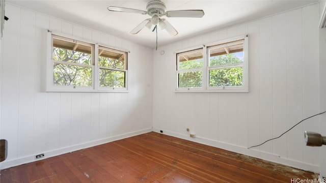 unfurnished room featuring dark hardwood / wood-style floors, ceiling fan, and a healthy amount of sunlight