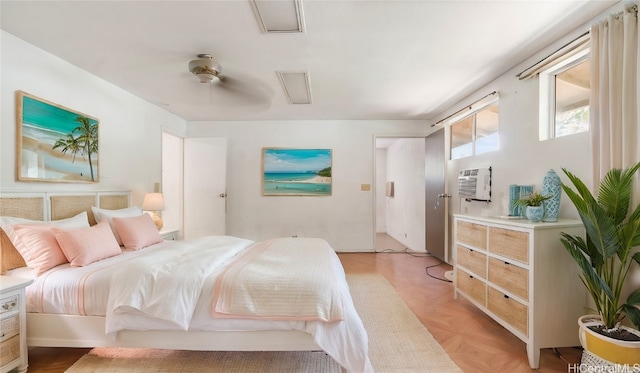 bedroom featuring a wall mounted AC, light parquet flooring, and ceiling fan