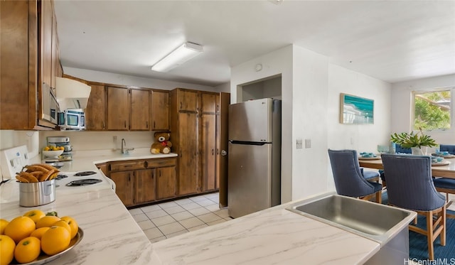 kitchen with sink, light tile patterned flooring, and appliances with stainless steel finishes