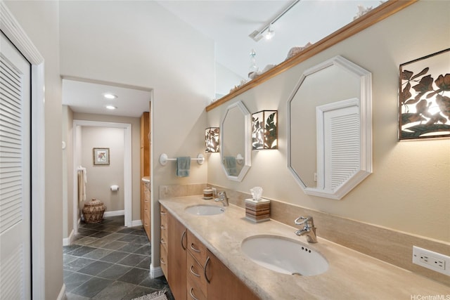 full bathroom featuring stone tile flooring, a sink, a closet, and double vanity