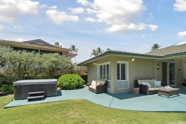 back of property with a patio area, a lawn, a hot tub, and stucco siding