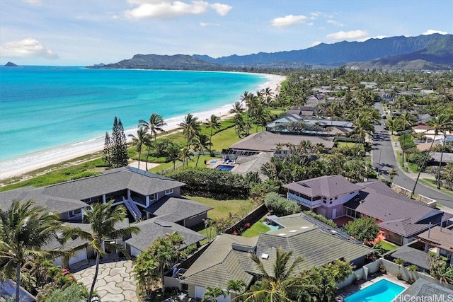 birds eye view of property with a water and mountain view and a beach view