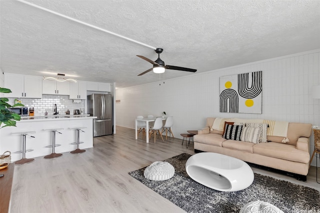 53-567 Kamehameha Hwy Unit 311, Hauula, HI 96717 - living area with light wood-style floors, a ceiling fan, and a textured ceiling
