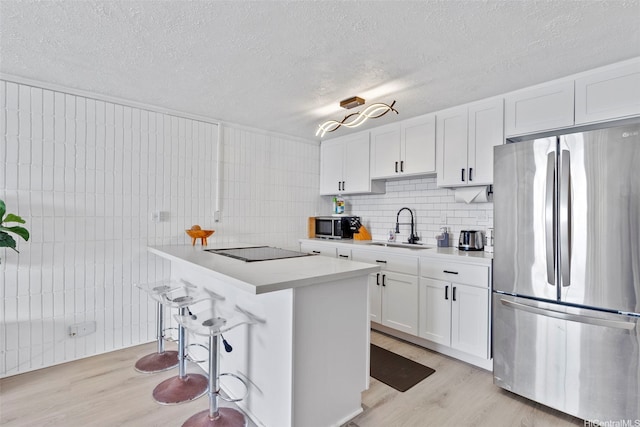 53-567 Kamehameha Hwy Unit 311, Hauula, HI 96717 - kitchen featuring stainless steel appliances, a sink, light wood-type flooring, white cabinetry, and a textured ceiling