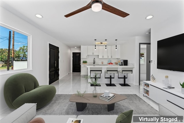 living room featuring ceiling fan and sink