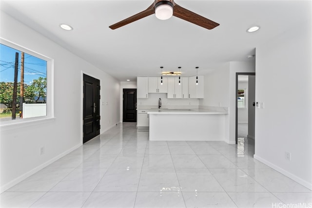 unfurnished living room with ceiling fan and sink