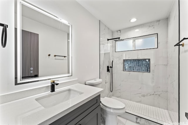 bathroom featuring vanity, toilet, and a tile shower