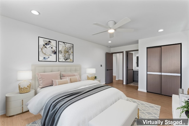 bedroom with ensuite bathroom, wood-type flooring, and ceiling fan