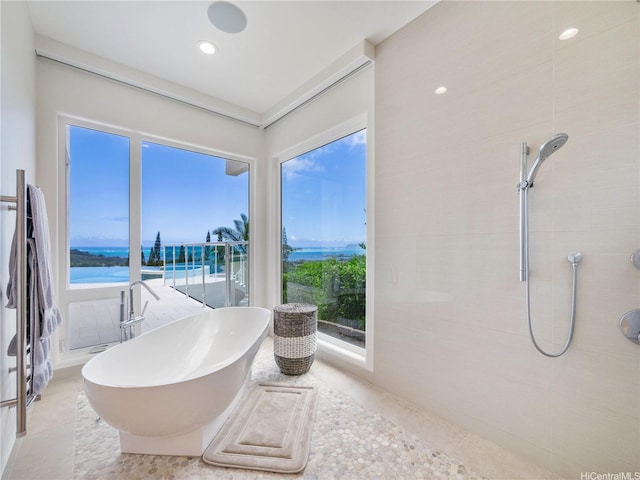 full bathroom with recessed lighting, a water view, tile patterned floors, a tile shower, and a freestanding bath