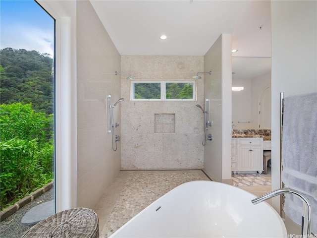 bathroom featuring a freestanding tub, recessed lighting, walk in shower, and vanity