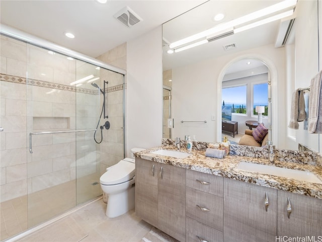 bathroom with vanity, toilet, tile patterned floors, and a shower with shower door