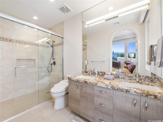 ensuite bathroom featuring a sink, a shower stall, and visible vents