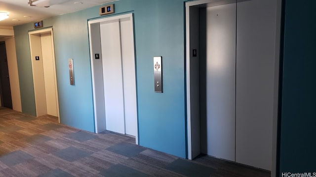 hallway with dark wood-type flooring and elevator