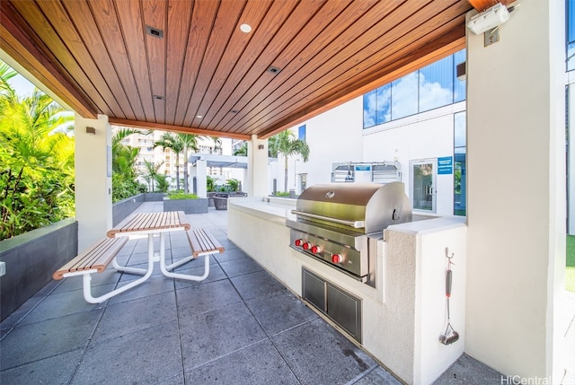 view of patio featuring exterior kitchen and a grill