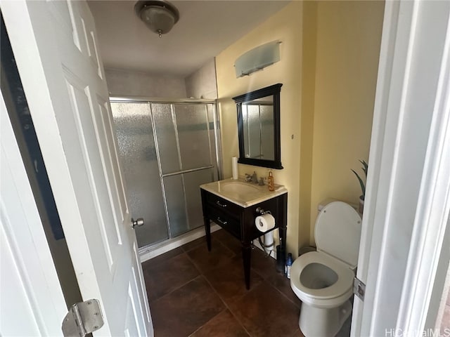 bathroom featuring toilet, an enclosed shower, vanity, and tile patterned floors