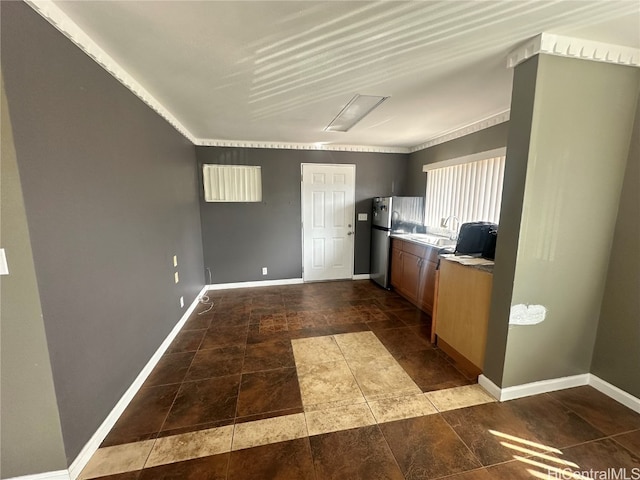 kitchen featuring sink, stainless steel fridge, and crown molding