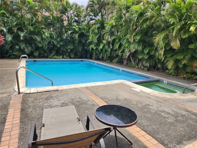 view of pool featuring an in ground hot tub and a patio