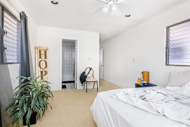 bedroom with ceiling fan, ensuite bathroom, and a barn door