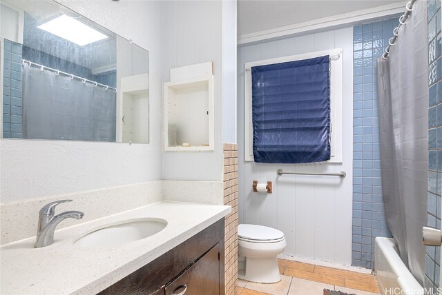 full bathroom with vanity, toilet, tile patterned floors, and shower / tub combo