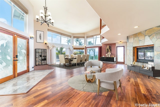 living room featuring a wealth of natural light, hardwood / wood-style floors, french doors, and a high ceiling