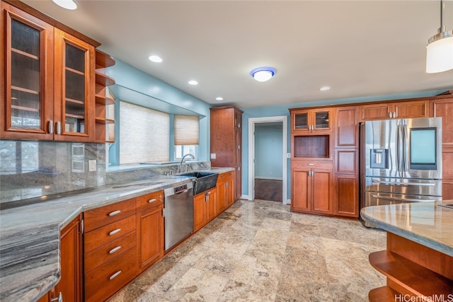 kitchen with tasteful backsplash, sink, stainless steel appliances, pendant lighting, and light stone counters