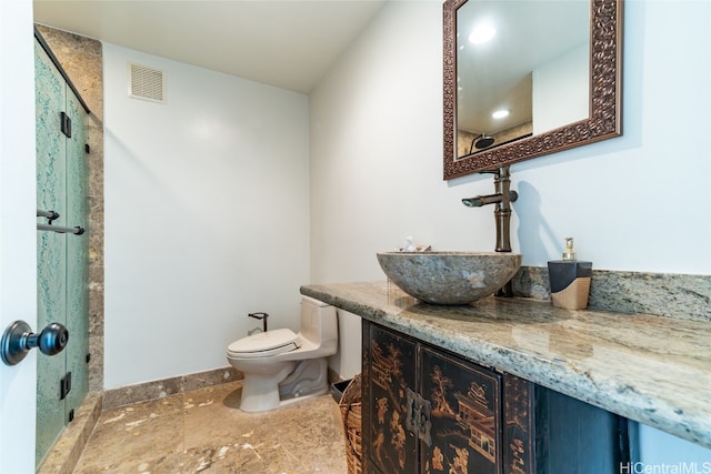 bathroom featuring vanity, toilet, and a shower with shower door