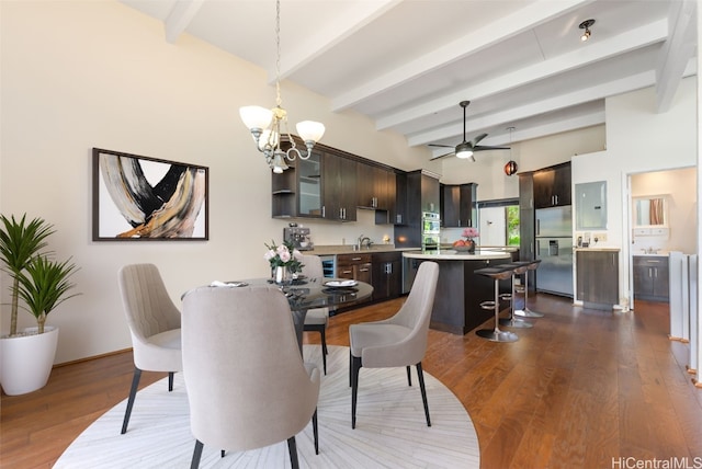 dining room featuring ceiling fan with notable chandelier, beamed ceiling, dark wood-type flooring, and sink