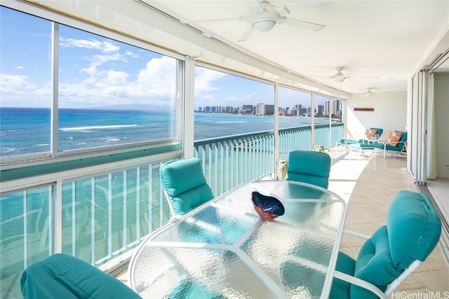 sunroom with a water view and ceiling fan