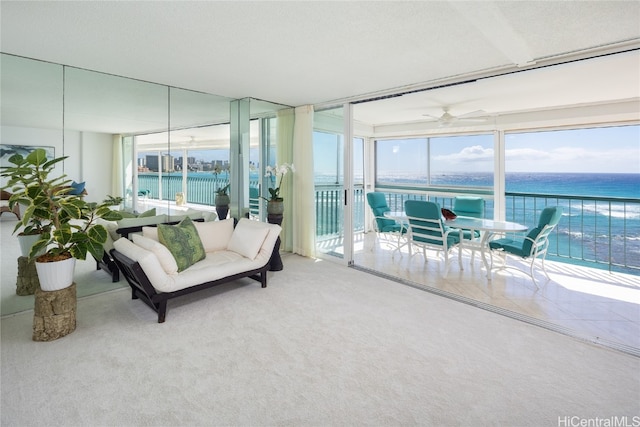 sunroom with a water view and ceiling fan