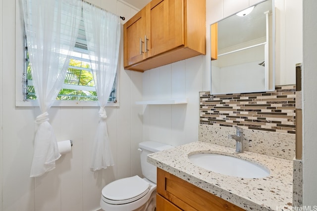 bathroom with backsplash, vanity, and toilet