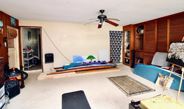 interior space with a textured ceiling, carpet, and ceiling fan