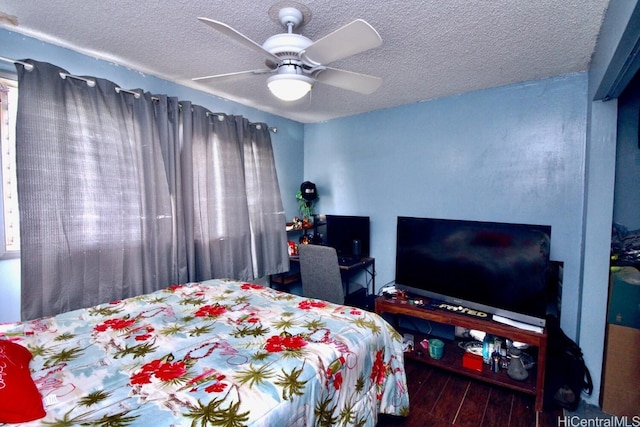 bedroom with ceiling fan, wood-type flooring, and a textured ceiling