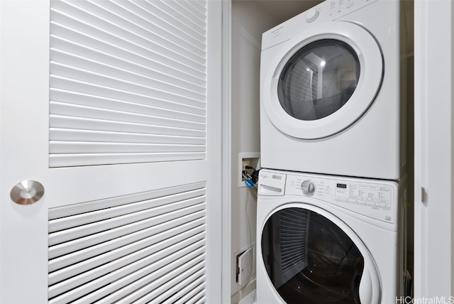 washroom featuring stacked washing maching and dryer