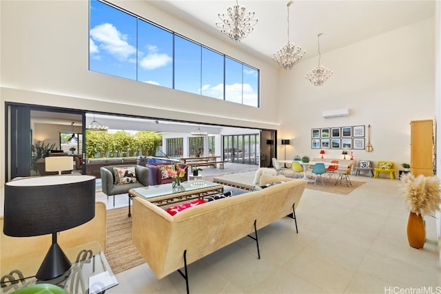 living room with a towering ceiling, a notable chandelier, and a wall unit AC