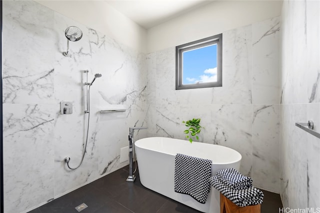 bathroom with tile walls, tile patterned flooring, and a bathing tub