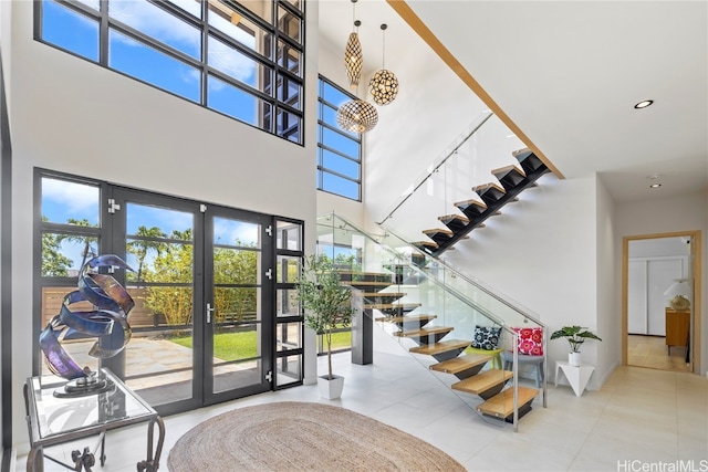 tiled entryway with french doors and a towering ceiling