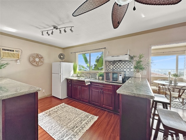 kitchen with sink, a wall mounted air conditioner, crown molding, white refrigerator, and dark hardwood / wood-style floors